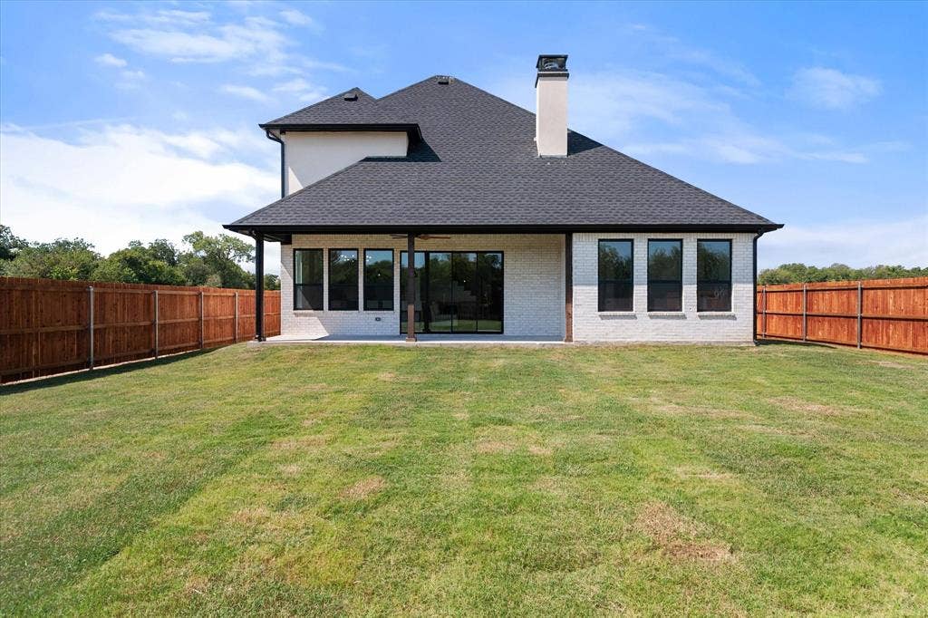 122 Yvonne Street, Red Oak, TX 75154 Rear view of the home with spacious backyad and stained fence