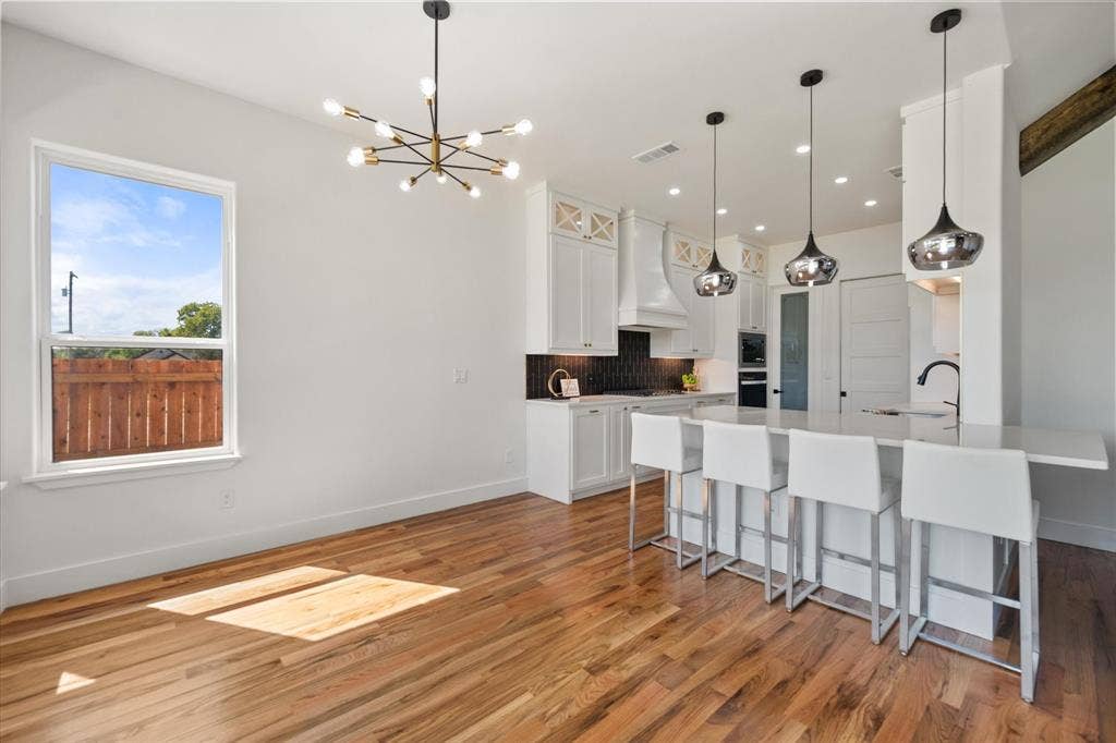 122 Yvonne Street, Red Oak, TX 75154 Eat in kitchen area with a Quartz extended countertop, modern pendant lighting and gleaming Oak wood floors