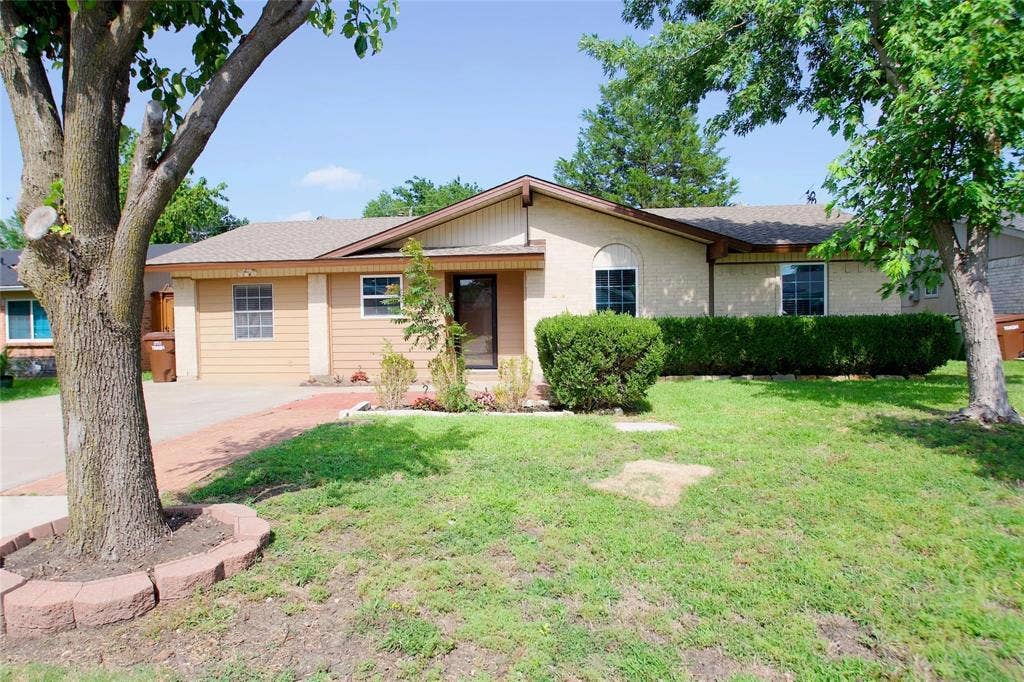 2708 N Avenue, Plano, TX 75074 Single-story exterior featuring a brick and horizontal siding facade, a gabled roofline, concrete driveway, and landscape beds with stone borders