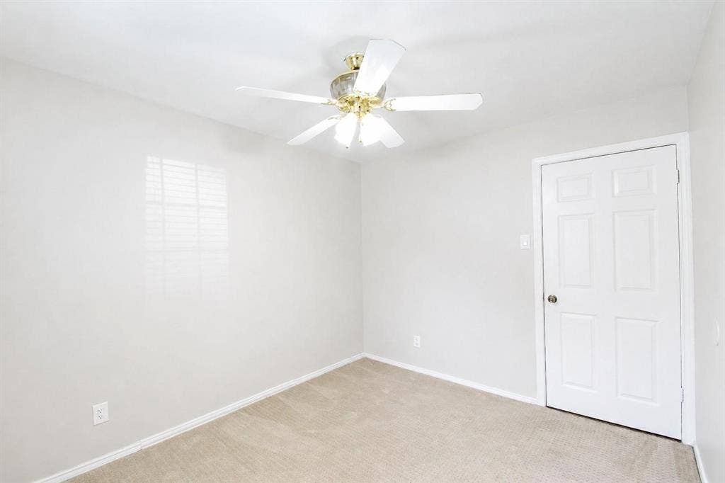 2708 N Avenue, Plano, TX 75074 Neutral-toned interior space featuring wall-to-wall carpeting, a six-panel interior door, and a multi-light ceiling fan