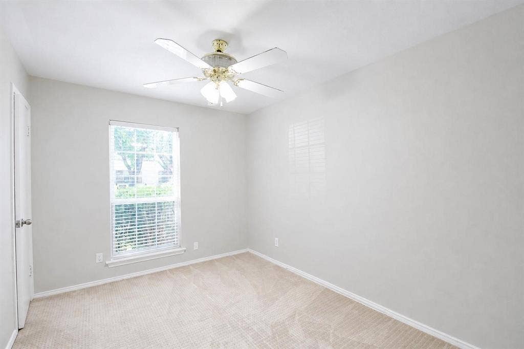 2708 N Avenue, Plano, TX 75074 Neutral wall tones, wall-to-wall carpeting, single-hung window with blinds, and a multi-blade ceiling fan with integrated light fixture