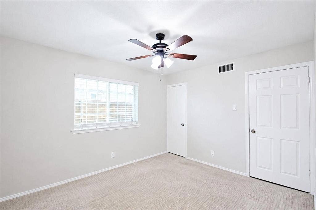 2708 N Avenue, Plano, TX 75074 Neutral-toned interior featuring wall-to-wall carpeting, a multi-pane window with blinds, a ceiling fan with integrated lighting, and two six-panel interior doors