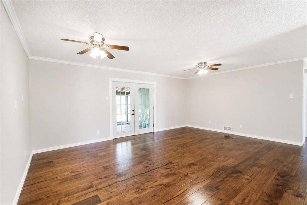 2708 N Avenue, Plano, TX 75074 Spacious room featuring wood-finish flooring, dual ceiling fans, and French doors
