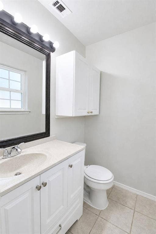 2708 N Avenue, Plano, TX 75074 Bathroom featuring white cabinetry, solid-surface countertop with an integrated sink, wall-mounted storage cabinet, framed mirror with integrated lighting, and tile flooring