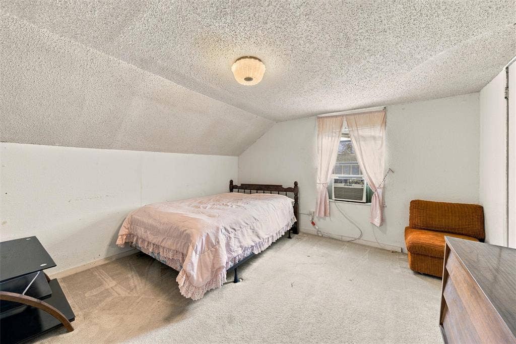 1703 Arra Street, Waco, TX 76704 Sloped ceiling featuring a textured finish, neutral carpeting, and a central dome-style ceiling light