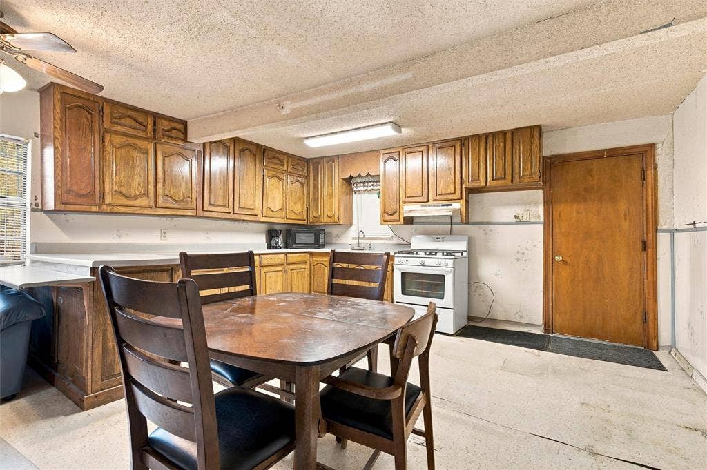 1703 Arra Street, Waco, TX 76704 Kitchen featuring wood cabinetry, integrated countertops, ceiling-mounted lighting, and a four-burner gas range