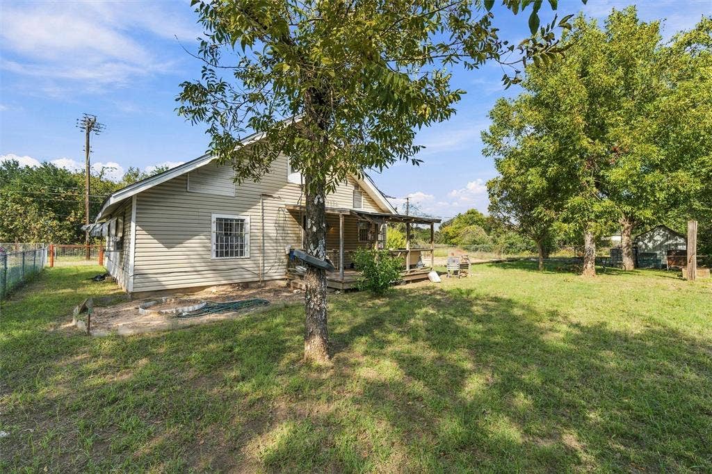 1703 Arra Street, Waco, TX 76704 Exterior featuring horizontal siding, a covered porch, grid-pattern windows, and a grassy lot with mature trees