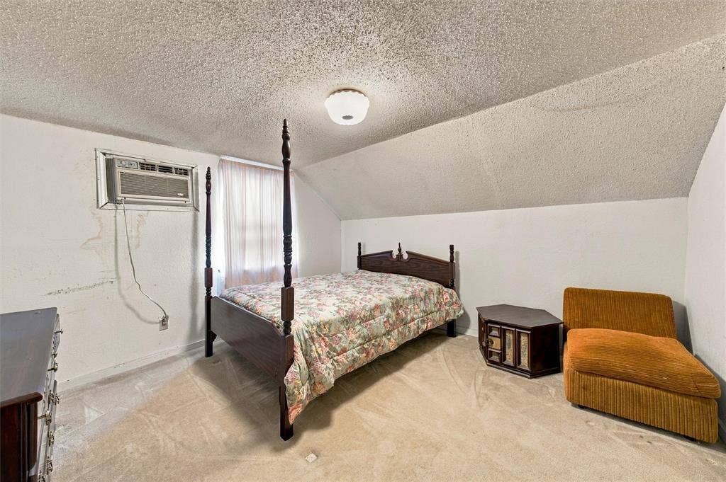 1703 Arra Street, Waco, TX 76704 Interior room featuring sloped ceilings, wall-to-wall carpeting, and a built-in wall-mounted air conditioning unit