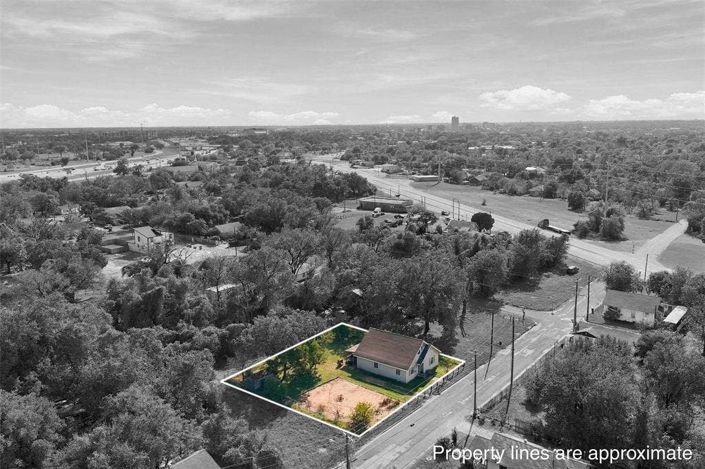 1703 Arra Street, Waco, TX 76704 Aerial perspective of a corner lot featuring a single-story residence, mature trees, and an open ground area