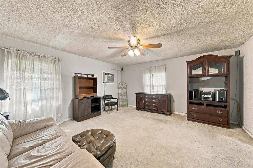 1703 Arra Street, Waco, TX 76704 Living area featuring textured ceiling, carpeted flooring, and a ceiling-mounted light fixture with a fan