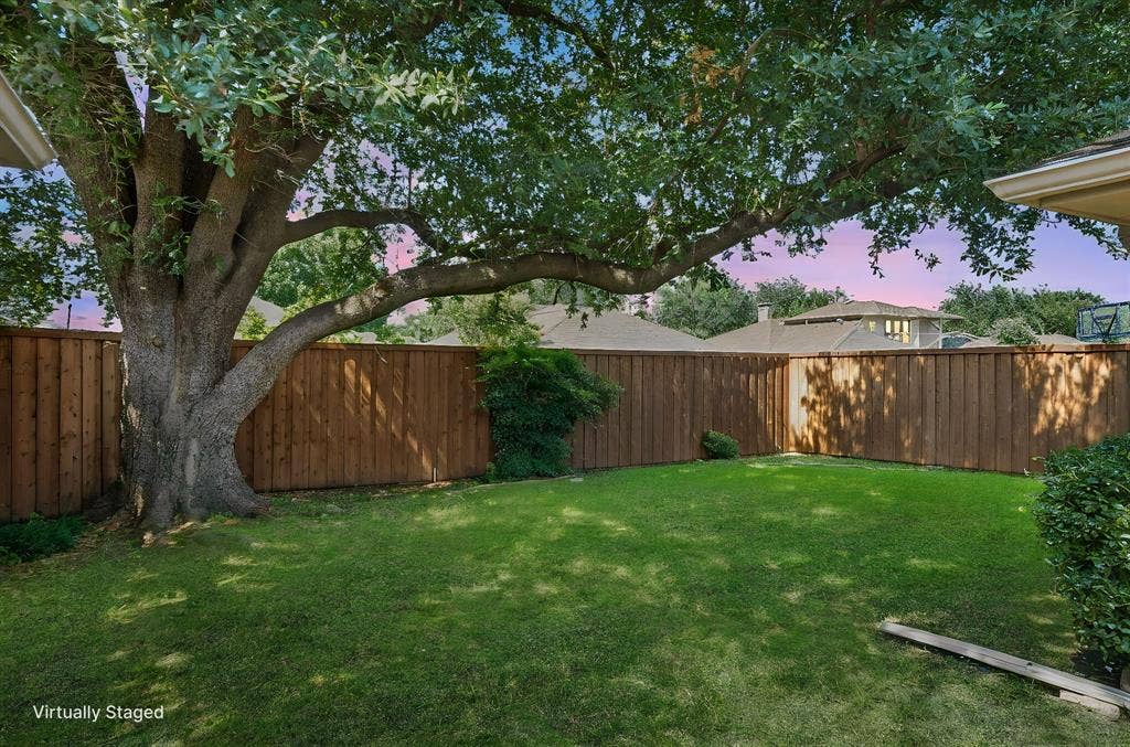 621 Harvest Glen Drive, Richardson, TX 75081 Backyard featuring a manicured lawn, mature shade tree, and wood privacy fencing