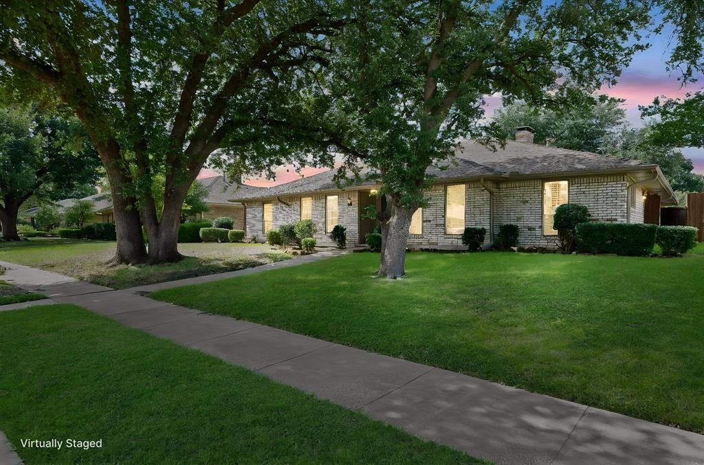 621 Harvest Glen Drive, Richardson, TX 75081 Single-story brick exterior featuring a hipped roof, mature shade trees, and a concrete walkway