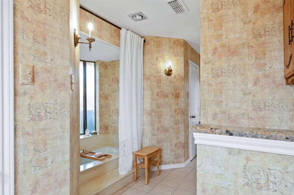 621 Harvest Glen Drive, Richardson, TX 75081 Built-in bathtub with a tile deck, wall-mounted candle-style lighting, recessed ceiling lighting, and a stone-topped vanity ledge