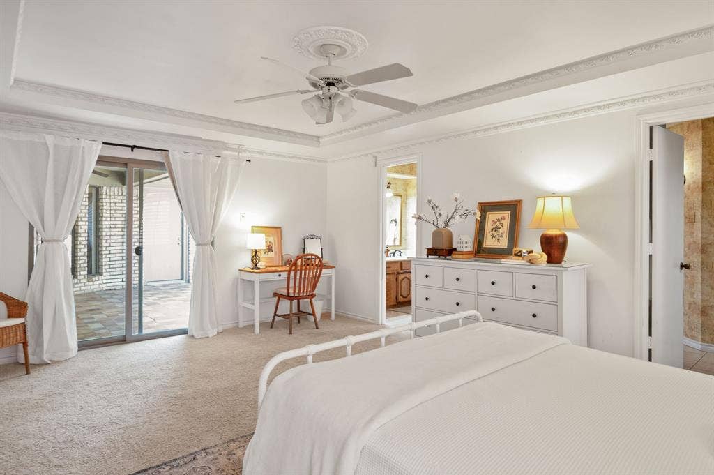 621 Harvest Glen Drive, Richardson, TX 75081 Tray ceiling with crown molding, ceiling fan with decorative medallion, and glass sliding door featuring exterior patio access