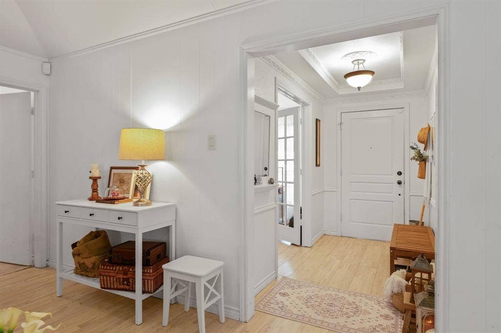 621 Harvest Glen Drive, Richardson, TX 75081 Interior entry featuring wood-finish flooring, white panel molding, a recessed ceiling tray with crown molding, a semi-flush mount light fixture with a decorative ceiling medallion, and a multi-panel door