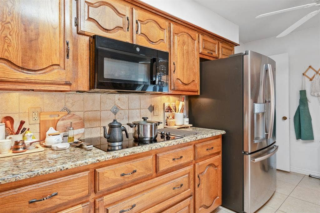 621 Harvest Glen Drive, Richardson, TX 75081 Kitchen featuring wood cabinetry, stone countertops, stone tile backsplash, integrated stainless steel appliances, and a glass cooktop