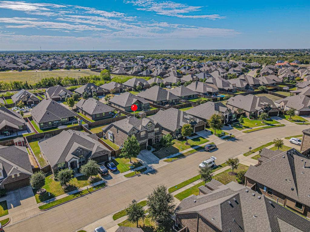 1742 Amalfi Drive, McLendon Chisholm, TX 75032 Aerial perspective of a multi-story residence featuring a brick and stone facade, an attached garage, a private driveway, and a rear lawn area