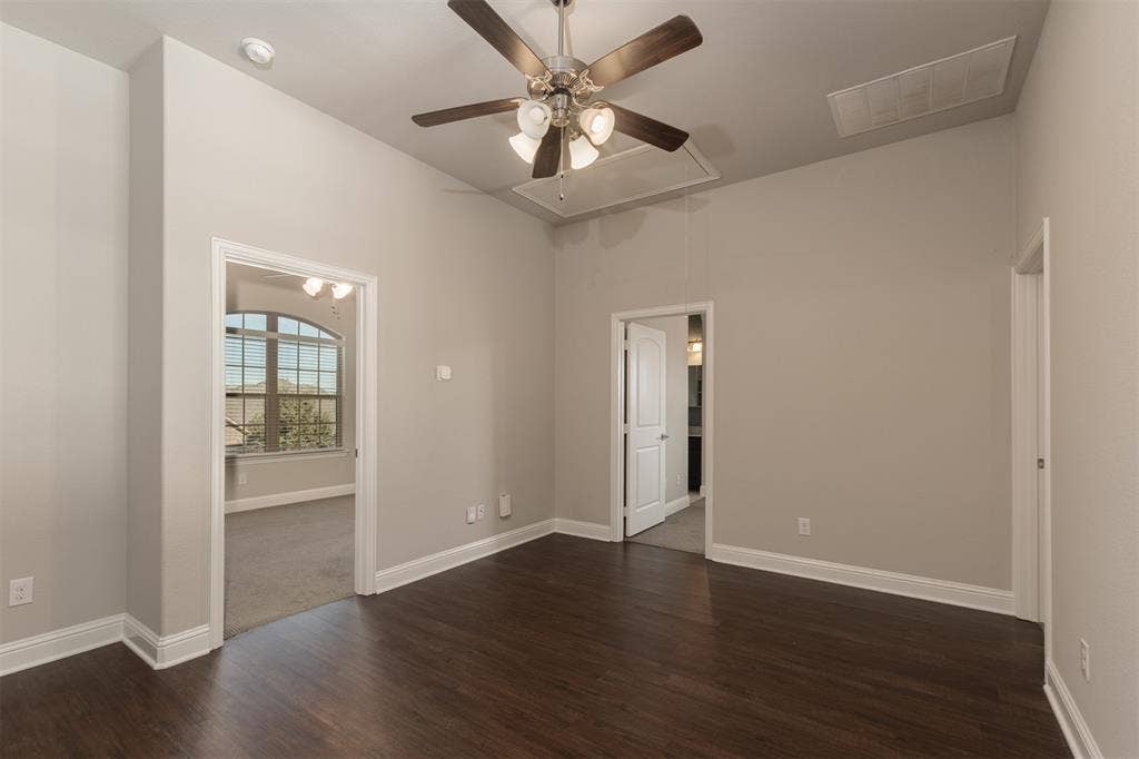 1742 Amalfi Drive, McLendon Chisholm, TX 75032 High-ceilinged room featuring dark wood-finish flooring, a multi-light ceiling fan, and arched window details