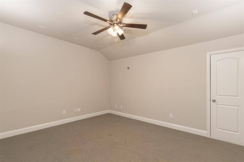 1742 Amalfi Drive, McLendon Chisholm, TX 75032 Neutral-toned interior featuring vaulted ceilings, wall-to-wall carpeting, and a multi-blade ceiling fan with integrated lighting