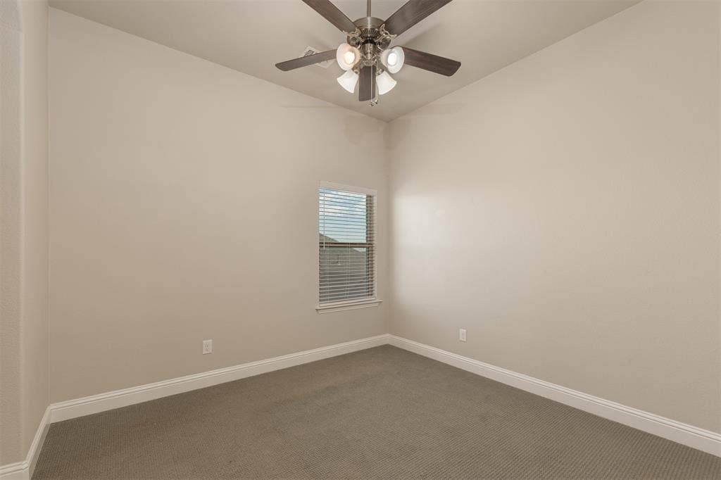 1742 Amalfi Drive, McLendon Chisholm, TX 75032 Neutral-toned room featuring textured carpeting, a multi-light ceiling fan with dark wood-finish blades, and a single window with horizontal blinds