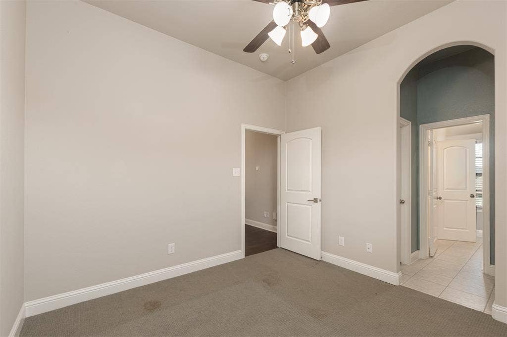 1742 Amalfi Drive, McLendon Chisholm, TX 75032 Room featuring high ceilings, a central ceiling fan with multi-light fixture, arched doorway, and solid-core paneled interior doors
