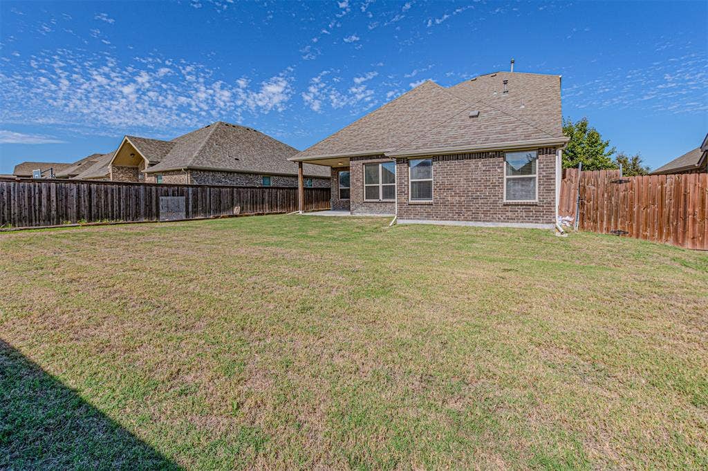 1742 Amalfi Drive, McLendon Chisholm, TX 75032 Rear exterior featuring brick masonry construction, a covered patio, and a fenced backyard
