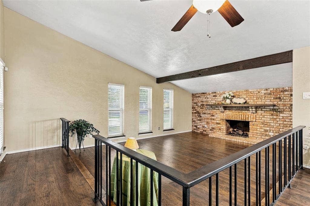 1901 Dodge Trail, Grand Prairie, TX 75052 Wide-angle view of the living room showcasing the floor-to-ceiling brick fireplace, vaulted ceiling, and abundant natural light.
