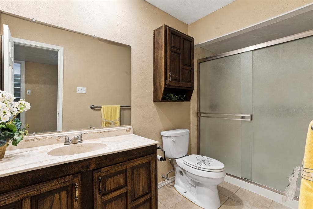 1901 Dodge Trail, Grand Prairie, TX 75052 Bathroom featuring a wood-finish vanity, ample countertop space, a walk in shower, and neutral finishes.