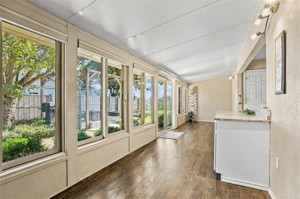 1901 Dodge Trail, Grand Prairie, TX 75052 Bright sunroom featuring expansive windows, abundant natural light, and wood-look flooring—ideal for enjoying views of the backyard.
