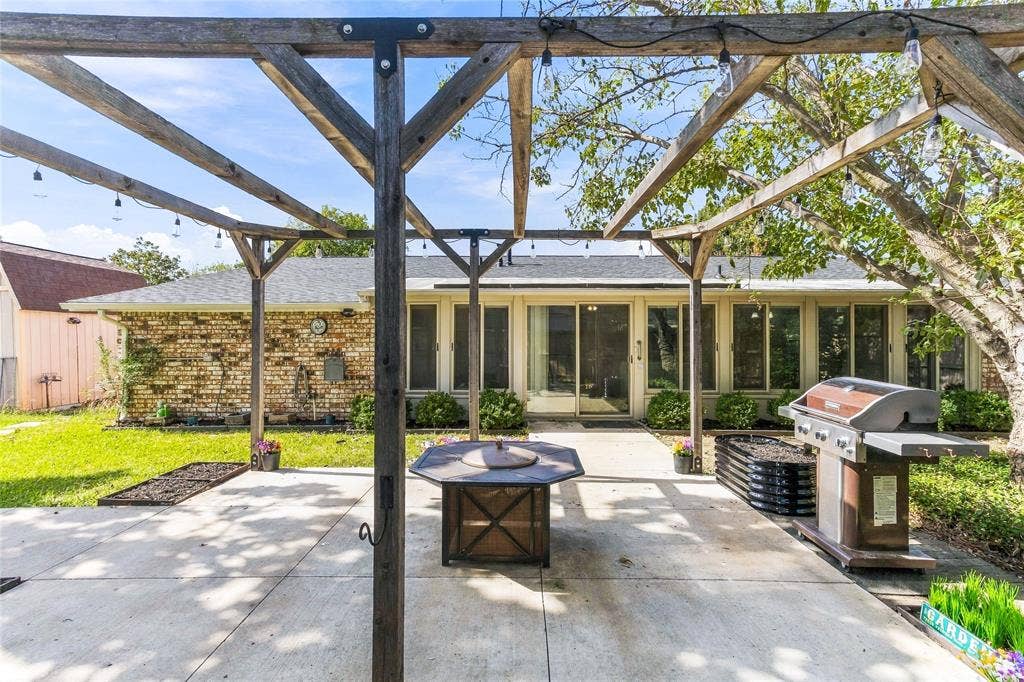 1901 Dodge Trail, Grand Prairie, TX 75052 Covered outdoor entertaining area featuring a pergola-style roof structure, outdoor grill, and patio space overlooking the backyard.