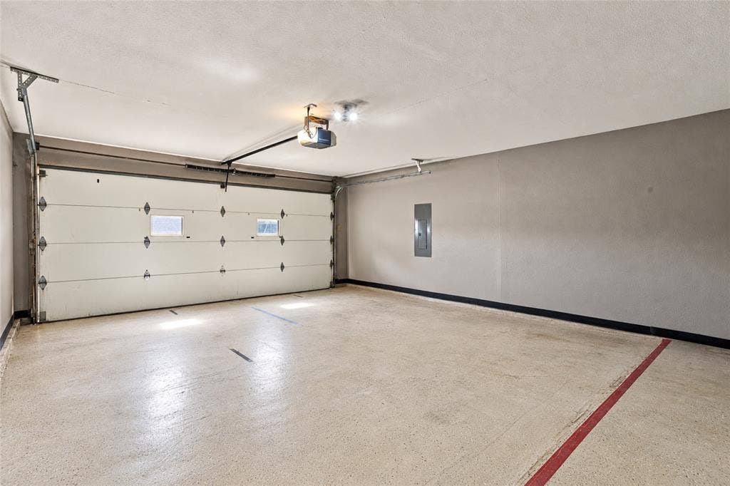 1901 Dodge Trail, Grand Prairie, TX 75052 Spacious two-car garage featuring a concrete floor, overhead garage door, and additional room for storage.