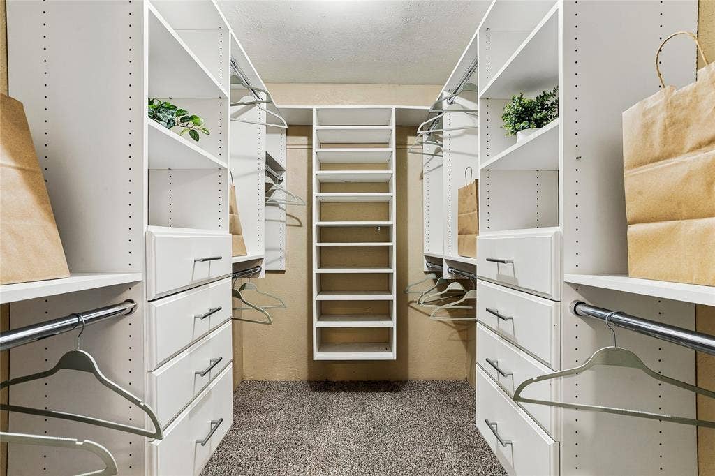 1901 Dodge Trail, Grand Prairie, TX 75052 Walk-in closet featuring built-in shelving, hanging space, and drawers for convenient storage and organization.