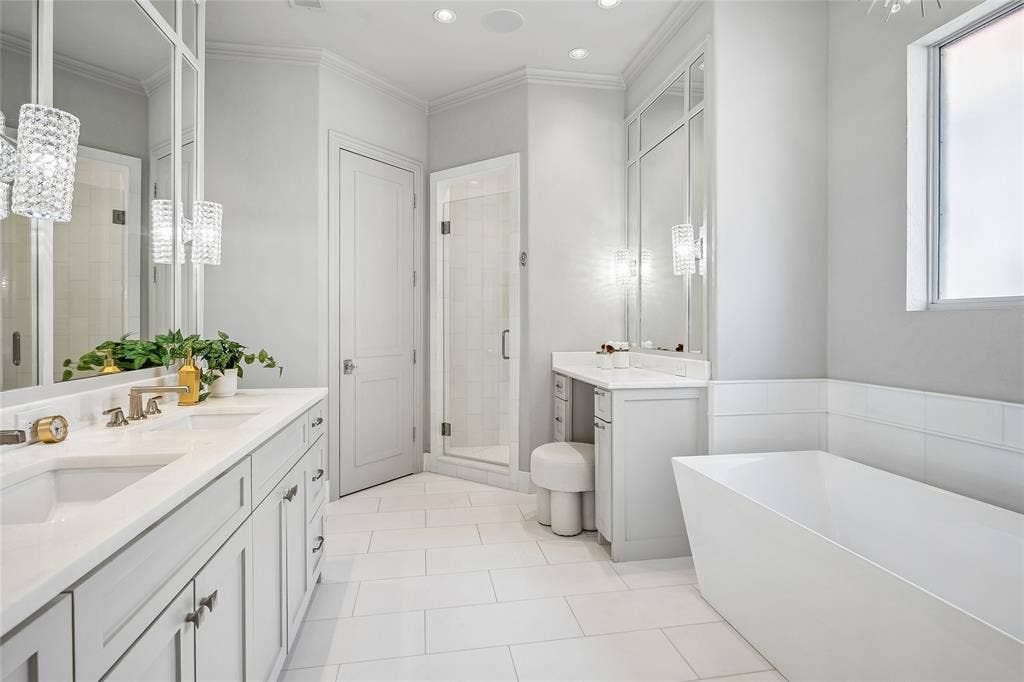 Spa-like primary bath in white and gray. Make-up counter and shower in background
