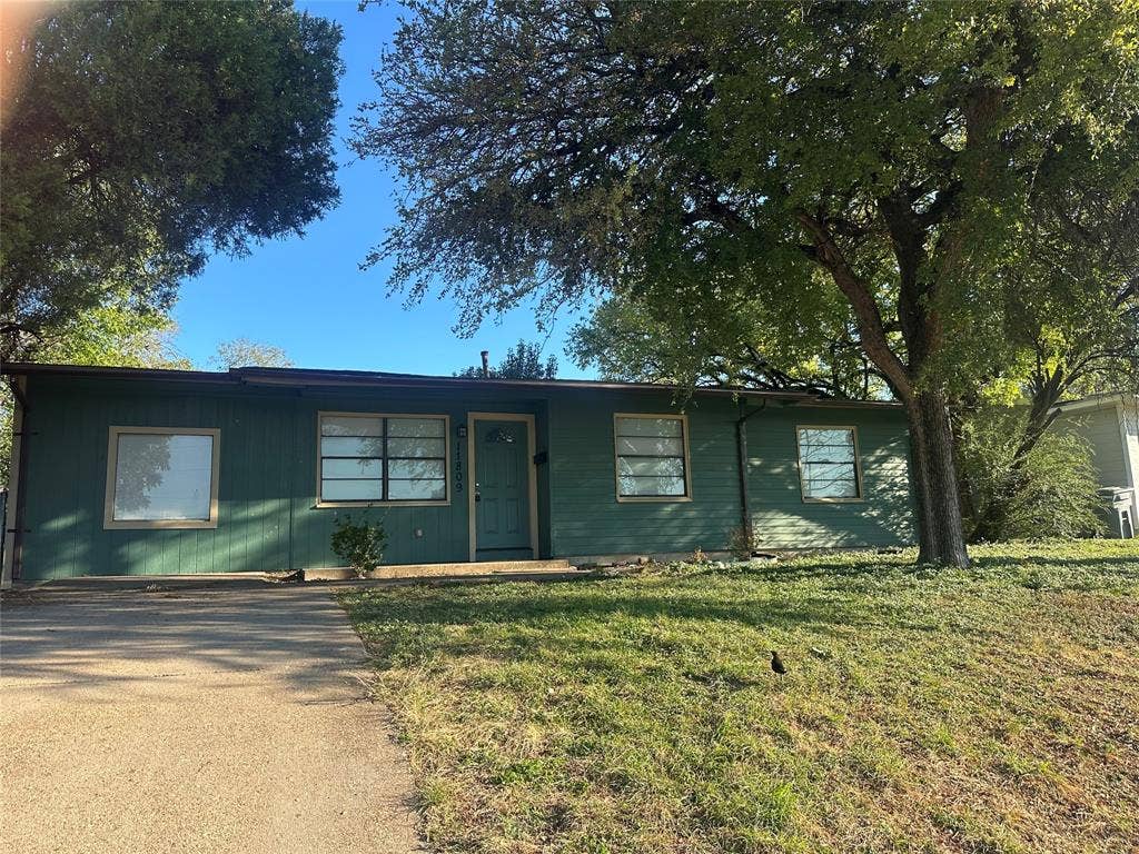 11809 Oberlin Drive, Dallas, TX 75243 Single-story residence featuring horizontal siding, a concrete driveway, multi-pane windows, and mature trees