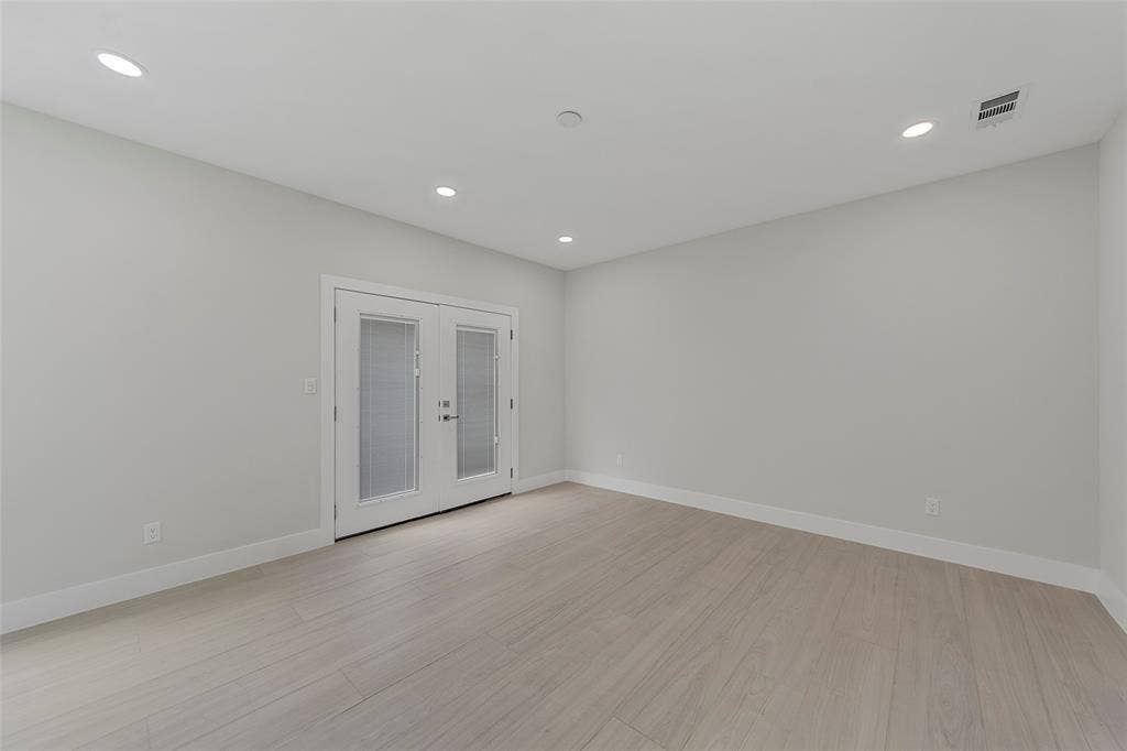 2503 Crossman Avenue, Dallas, TX 75212 Neutral-toned room featuring wood-finish flooring, recessed lighting, and double glass-paneled doors