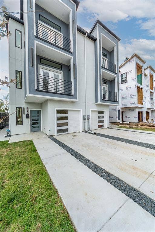 2503 Crossman Avenue, Dallas, TX 75212 Contemporary three-story exterior featuring a smooth stucco finish, dual-level balconies with metal railings, and a multi-pane glass garage door