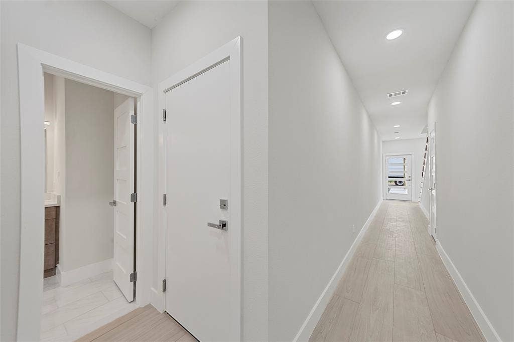 2503 Crossman Avenue, Dallas, TX 75212 Neutral-toned interior hallway featuring wood-finish flooring, recessed lighting, and a multi-lite exterior entry door with a frosted glass panel