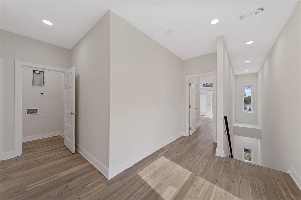 2503 Crossman Avenue, Dallas, TX 75212 Neutral-toned interior featuring wood-finish flooring, recessed lighting, four-panel interior doors, and a staircase with a minimalist black handrail
