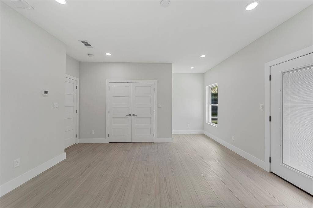 2503 Crossman Avenue, Dallas, TX 75212 Neutral-toned interior space featuring wood-finish flooring, recessed lighting, double-panel interior doors, and a glass-paneled exterior door