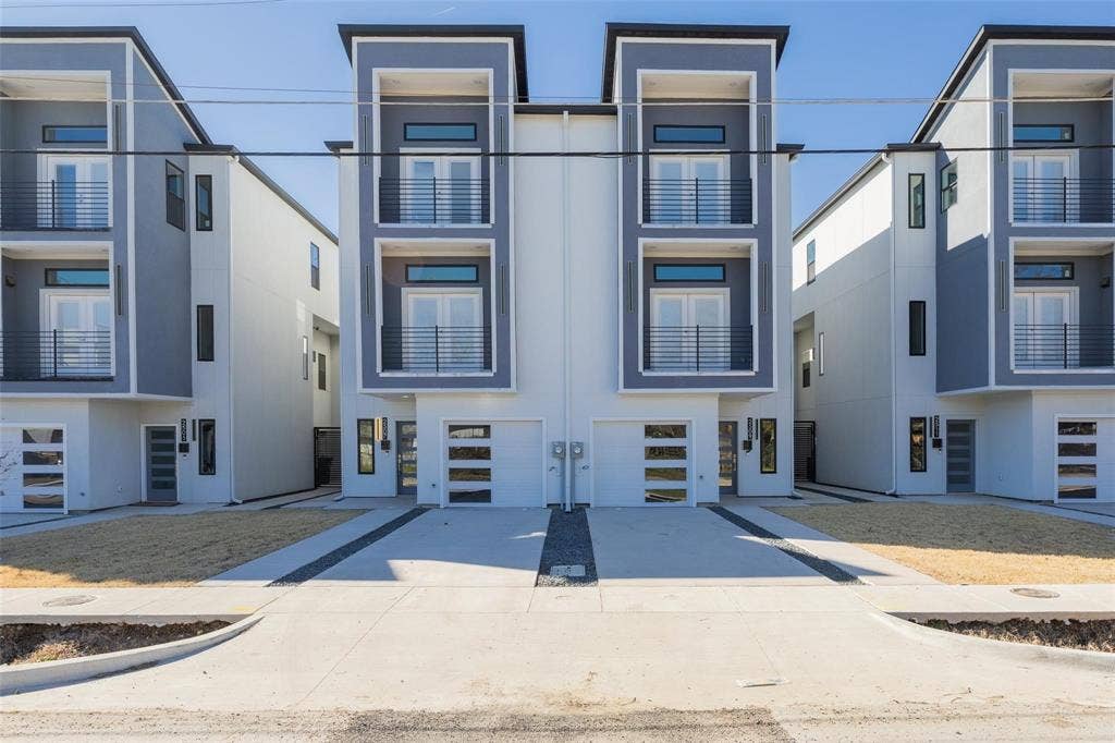 2503 Crossman Avenue, Dallas, TX 75212 Contemporary multi-story exterior featuring a smooth stucco facade, dual-level balconies with metal railings, and attached garages with horizontal glass-paneled doors