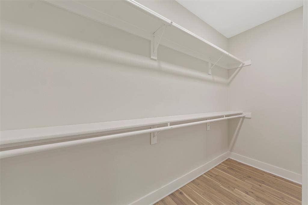 2503 Crossman Avenue, Dallas, TX 75212 Walk-in closet featuring tiered shelving, integrated clothing rods, and wood-finish flooring