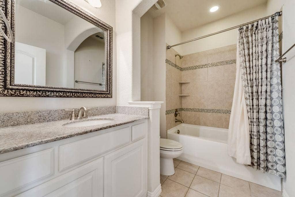 636 S Greenville Avenue, Richardson, TX 75081 Full bathroom featuring shower / bath combo, tile patterned flooring, toilet, and vanity