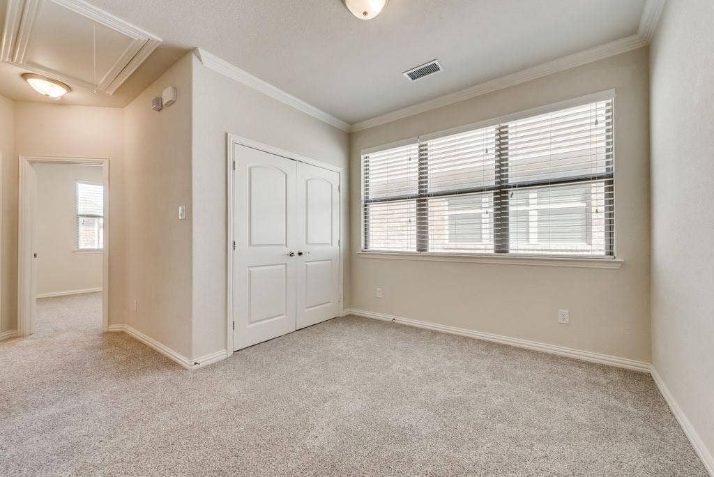 636 S Greenville Avenue, Richardson, TX 75081 Unfurnished bedroom with multiple windows, light colored carpet, and a closet