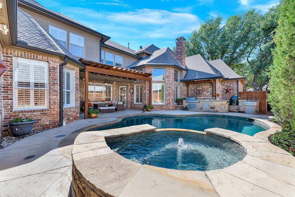 2608 LAWTON Lane, Plano, TX 75093 A central bubbling fountain water feature cascades gently over stone coping into the main pool basin. Picture listening to the soothing sound of flowing water as day turns to dusk across your private oasis.