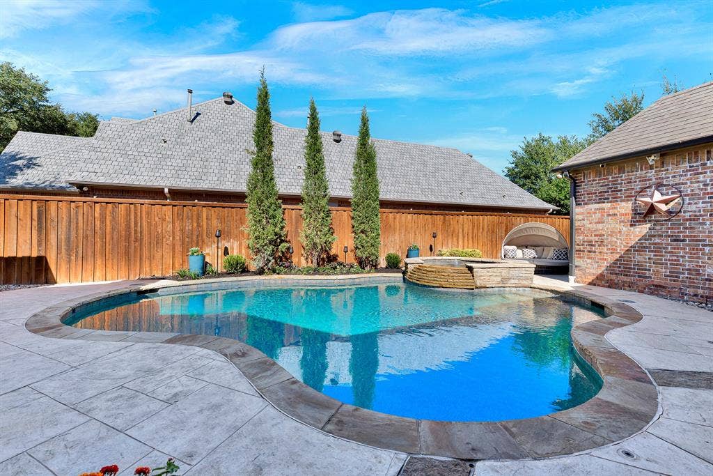2608 LAWTON Lane, Plano, TX 75093 Freeform stone edging shapes a sparkling turquoise pool anchored by an elevated stone spa centerpiece. You will love taking an afternoon dip to cool off or relaxing in the spa under clear blue skies.