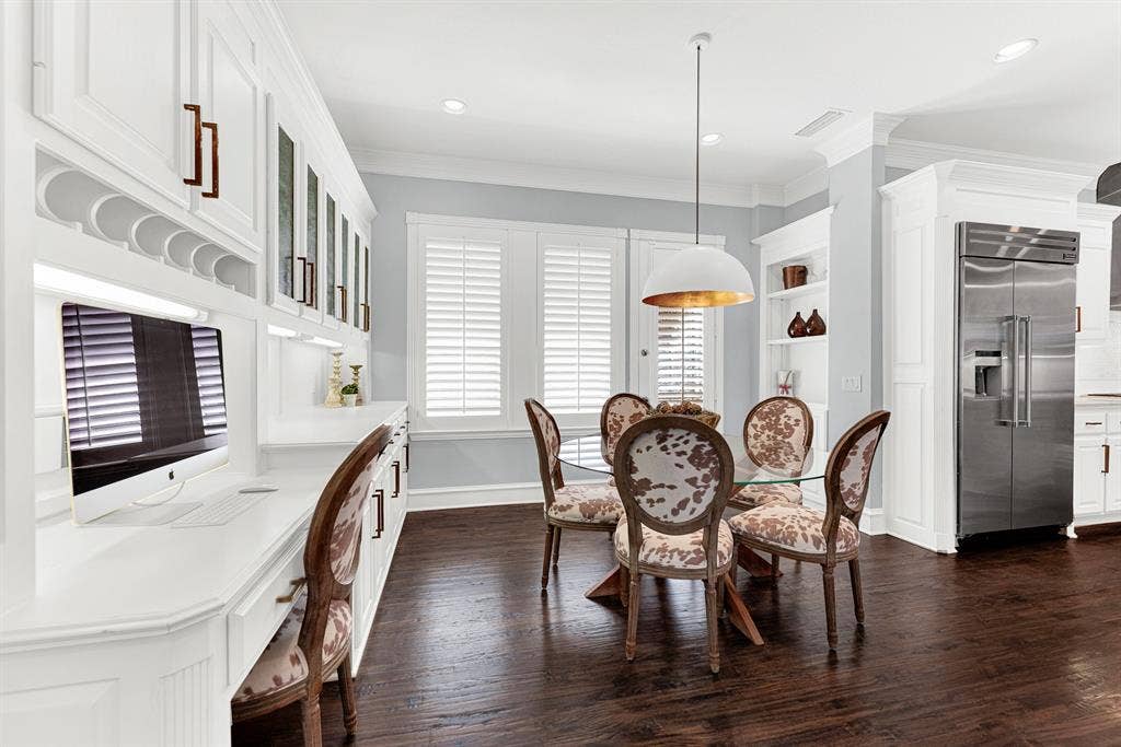 2608 LAWTON Lane, Plano, TX 75093 Seamless built-in storage cabinets and an integrated workstation turn this casual dining space into a multifunctional hub. It is a cozy haven for helping kids finish homework right before gathering together for family dinner.