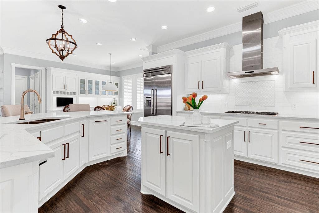 2608 LAWTON Lane, Plano, TX 75093 A center Prep island and Thermador professional-grade stainless range hood optimize work flow across rich, dark wood floors. You will love chopping fresh herbs and prepping party appetizers while guests mingle comfortably nearby
