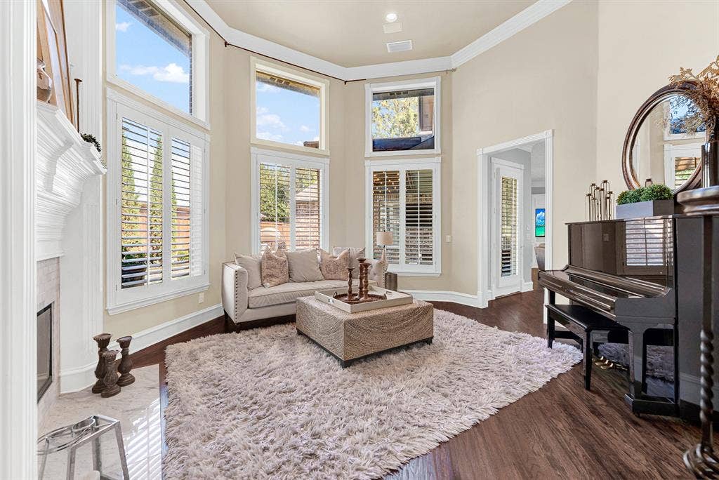 2608 LAWTON Lane, Plano, TX 75093 A dramatic two-story bay of shuttered windows creates a sun-drenched architectural focal point across the rich wood floors. Imagine unwinding with a chilled glass of wine while background piano tunes fill the airy, sunlit room.