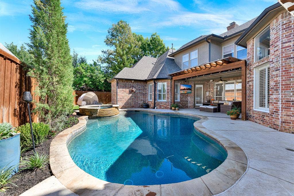 2608 LAWTON Lane, Plano, TX 75093 A sprawling covered pergola patio seamlessly bridges the home's rear brick profile with the sparkling swimming pool. Imagine spending relaxed weekend afternoons alternating between swimming laps and lounging in the shade.