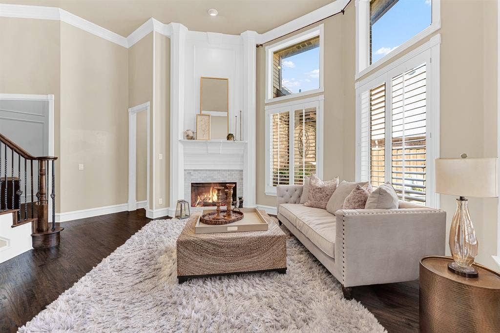 2608 LAWTON Lane, Plano, TX 75093 A full-height hearth flanked by custom wall trim draws the eyes up toward the towering, vaulted ceiling line. Picture curling up on a cool autumn night next to a crackling fire, completely cozy and at ease